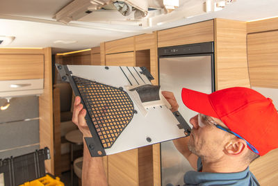 Technician repairing lighting equipment at camper van