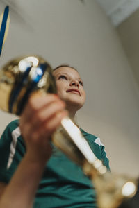 Ambitious girl with trophy sitting at home