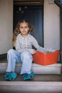 Portrait of smiling young woman sitting at home