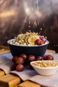 A plate of cottage cheese with granola, grapes and banana. healthy and delicious food for breakfast. 