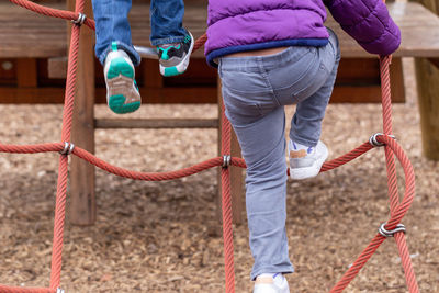 Low section of children playing on jungle gym in playground