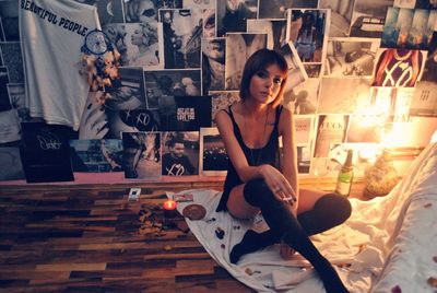 Portrait of woman holding cigarette while sitting in room