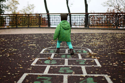 Rear view of boy playing at playground