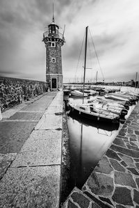 Lighthouse by sea against sky