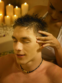 Girlfriend giving head massage to boyfriend in bathtub