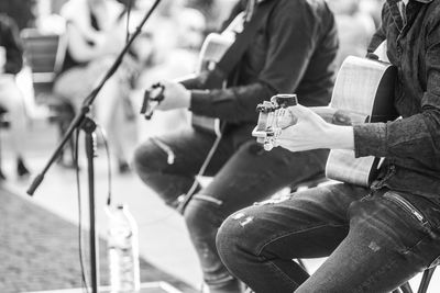 Midsection of men playing guitar