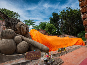 Statue by temple against sky