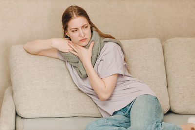 Young woman sitting on sofa at home