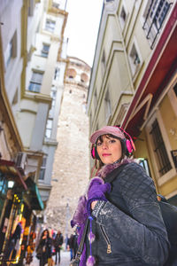 Portrait of woman standing on street in city