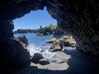Rocks on beach against clear sky