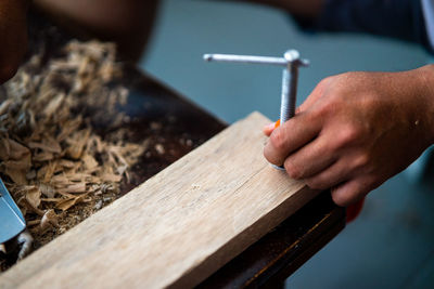 Cropped hands of person working with wood