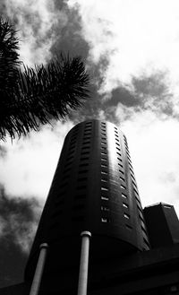 Low angle view of skyscraper against cloudy sky