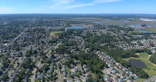 High angle view of townscape by sea against sky