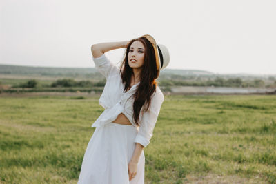 Portrait of young woman standing on field