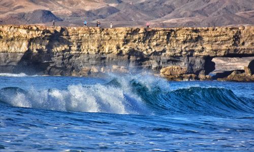 Scenic view of sea waves splashing on rocks