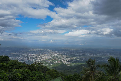 Aerial view of city by sea against sky