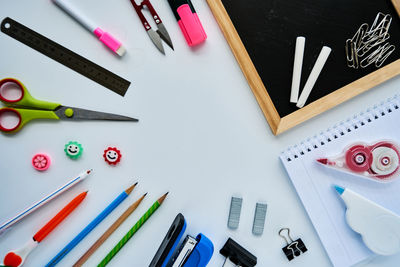 Directly above shot of writing slate with school supplies on table