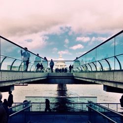 Bridge over river against cloudy sky