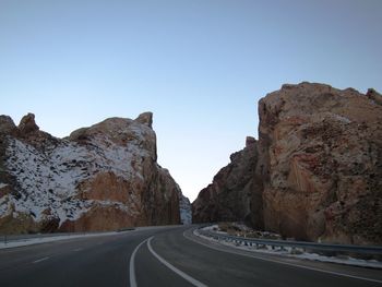 Road amidst mountains against clear sky