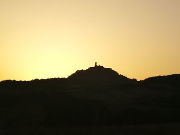 Silhouette man standing on mountain against clear sky