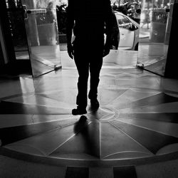 Low section of man standing on tiled floor