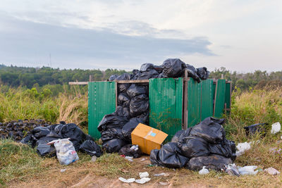 Garbage bin in field against sky