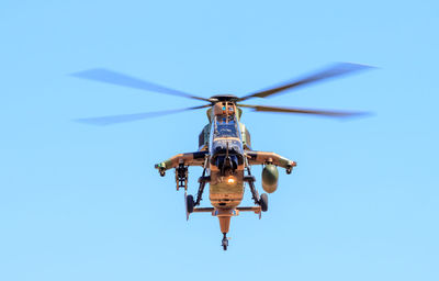 Low angle view of helicopter flying against clear blue sky