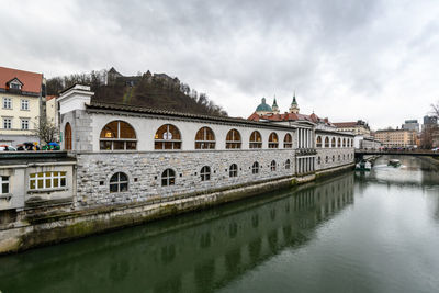 View of buildings in town against cloudy sky