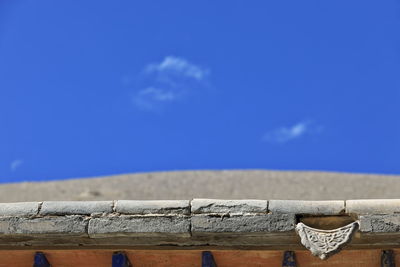 Low angle view of railing against blue sky