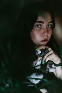 Close-up portrait of beautiful woman in darkroom