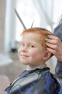 Stylish redhead boy at the barbershop. boy 4 years old in the barbershop looks at the camera