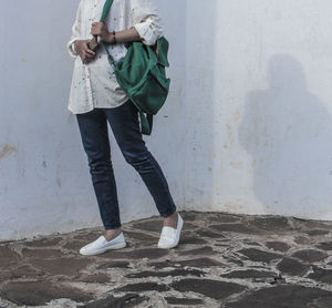 Low section of woman standing on wall