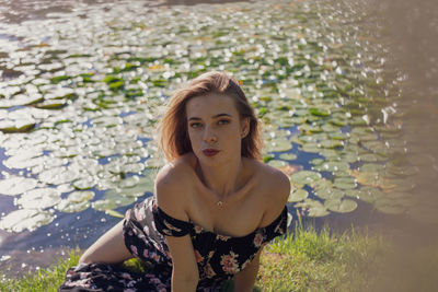 Portrait of beautiful woman lying down by lake