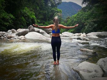 Full length rear view of happy woman in water