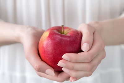 Midsection of woman holding apple