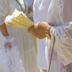 Midsection of woman holding hand fan