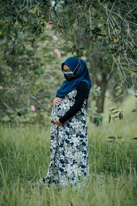 Midsection of woman standing on field