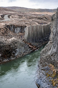 Beautiful view of stream flowing amidst basalt columns formation at eastfjords