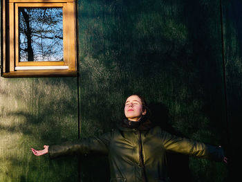 Portrait of woman standing at wall