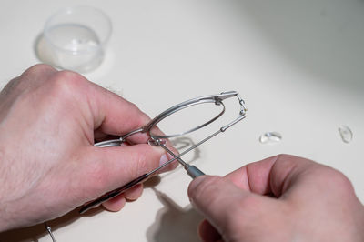 Cropped hand of person holding dentures