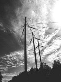 Low angle view of silhouette electricity pylon against sky