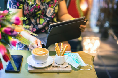 Coffee cup and laptop on table