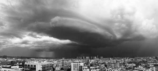 Panoramic view of cityscape against storm clouds