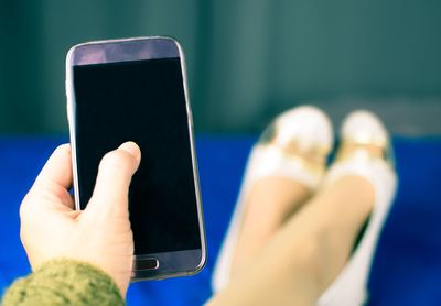 Low section of woman using mobile phone at home