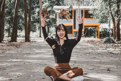 Portrait of smiling young woman sitting on land