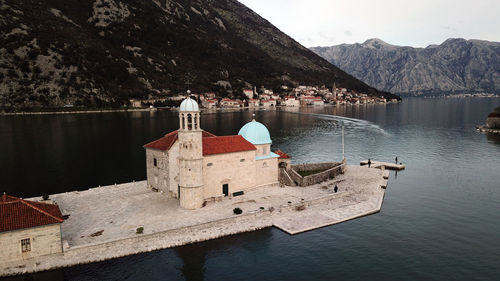 Building by lake against sky