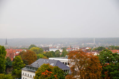 High angle view of houses and trees against clear sky