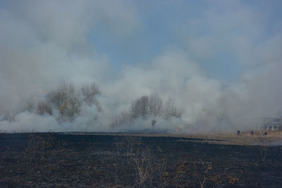 Smoke emitting from volcanic landscape against sky