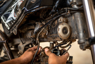 Cropped hands of mechanic repairing motorcycle