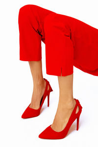 Fashion unrecognizable lady legs in red pants and shoes. minimalist elegant details style.